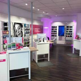 Moderner Telekom Shop mit Beratungstresen, Smartphone-Zubehör und digitaler Produktpräsentation.
